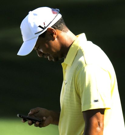 Fourteen-time major winner Tiger Woods checks out his mobile during a practice round, though the former world No. 1 is a sporadic tweeter to his following of over four million.
