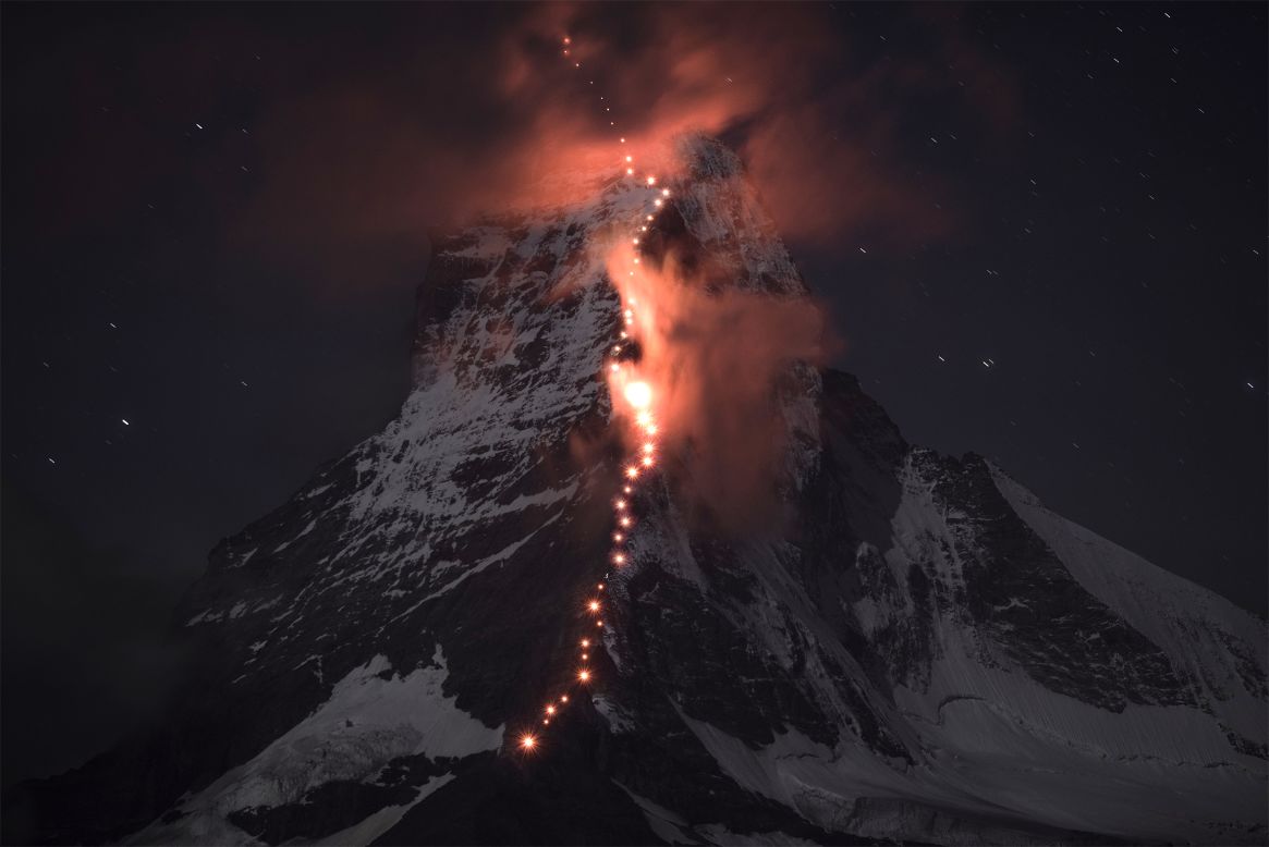 SEPTEMBER 17 - ZERMATT, SWITZERLAND: Matterhorn, one of the highest peaks of the Swiss Alps, is illuminated by the torch lights of climbers celebrating the 150th anniversary of the first ascent of the mountain. Matterhorn is popular worldwide and regarded as the emblem of the Alps.
