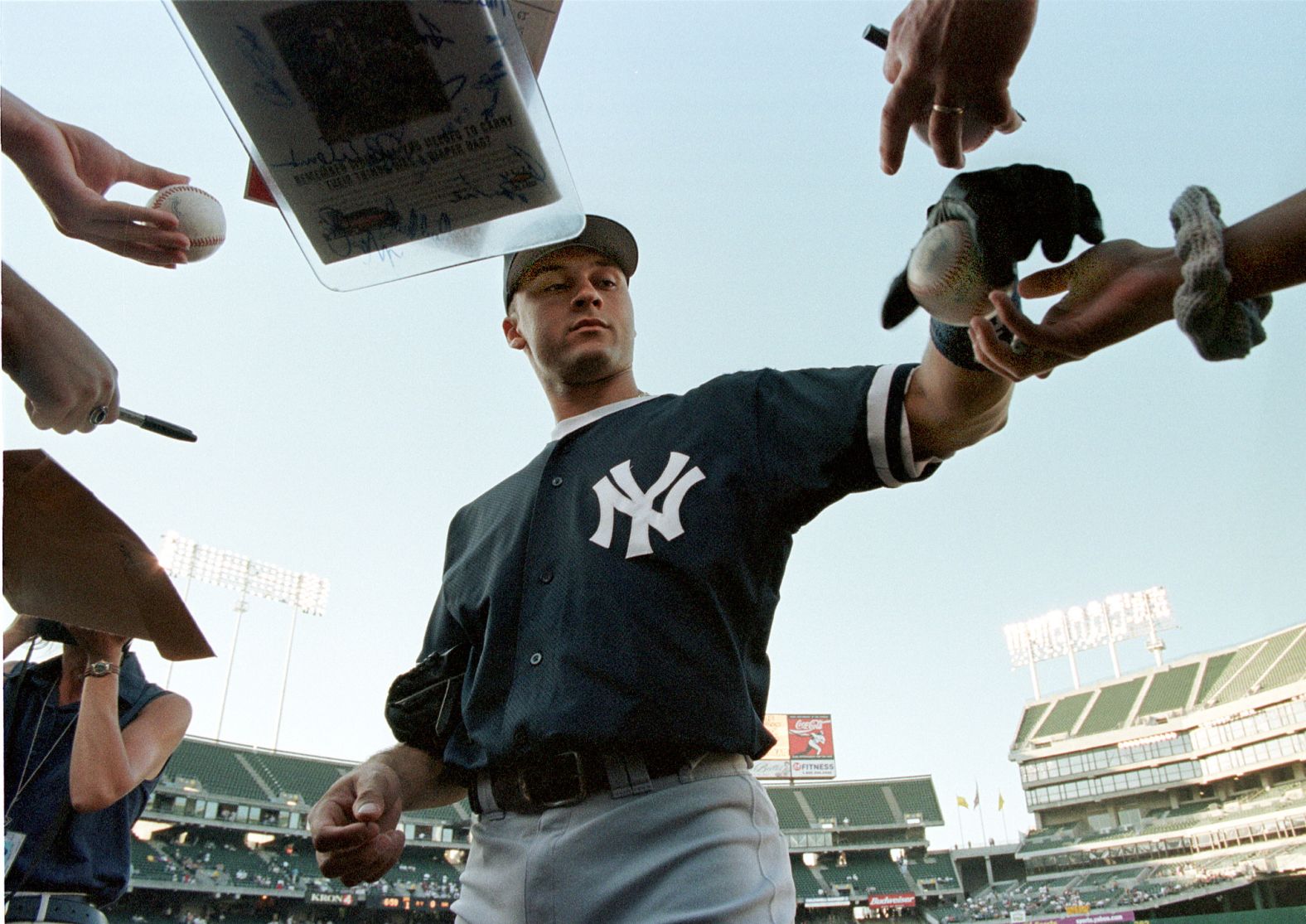 Jeter signs autographs before a game in Oakland in August 1998.