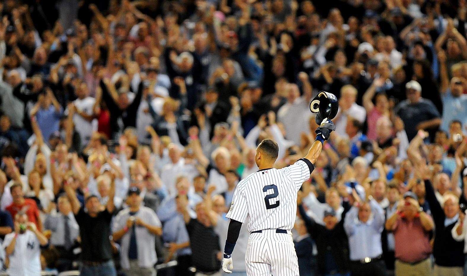 Jeter tips his helmet to an adoring crowd at the new Yankee Stadium after he tied the team record for career hits in September 2009. He would later go on to break that record, which had been held by Lou Gehrig.