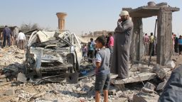 Syrian civilians stand at the site where a Syrian government forces aircraft fell after it was shot down by militants of the Islamic State (IS) group over the Syrian town of Raqa on September 16, 2014. The plane crashed into a house in the Euphrates Valley city, the sole provincial capital entirely out of Syrian government control, causing deaths and injuries on the ground,  Syrian Observatory for Human Rights monitoring group said. AFP PHOTO/RMC/STR        (Photo credit should read )