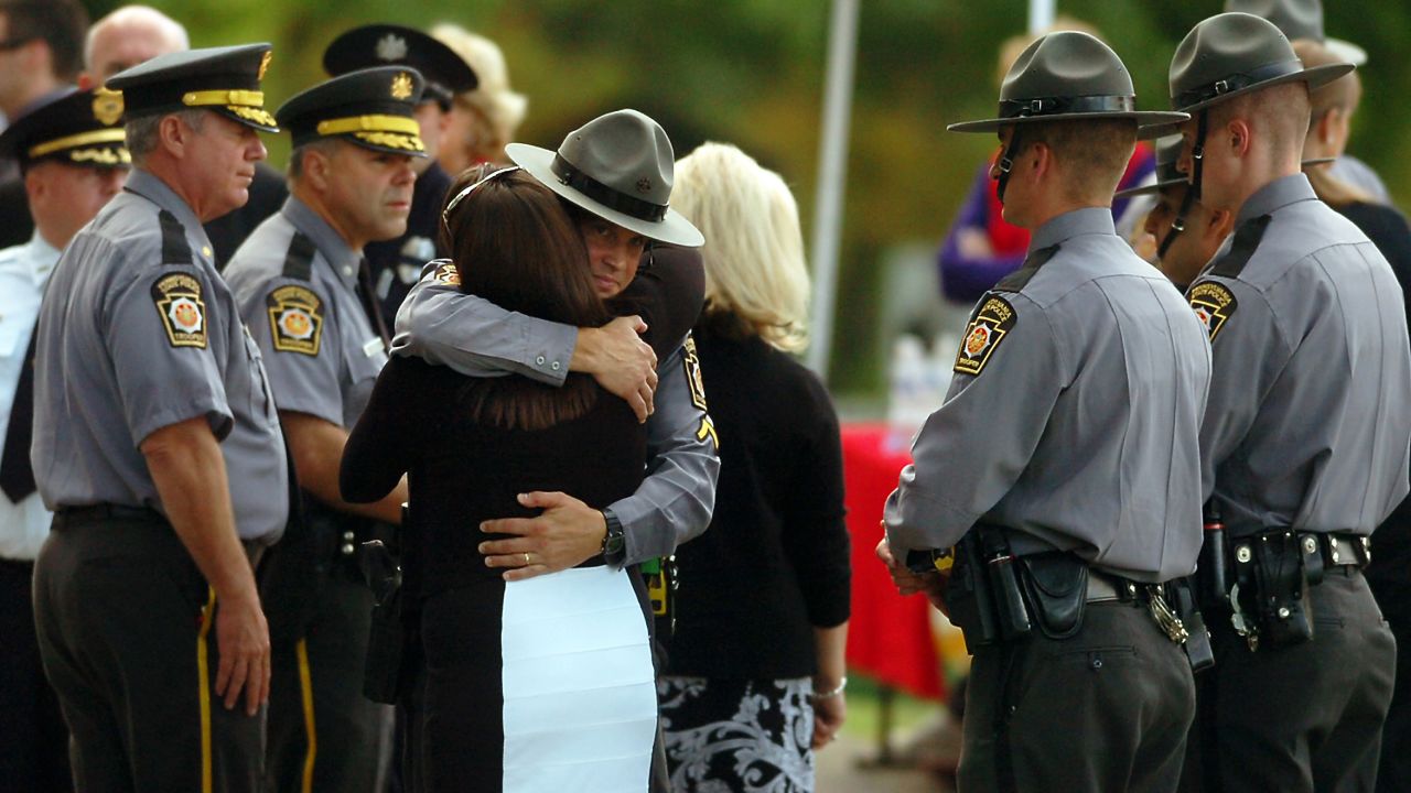 A woman embraces a Pennsylvania state trooper during the viewing of Dickson's body Wednesday, September 17, in Scranton.