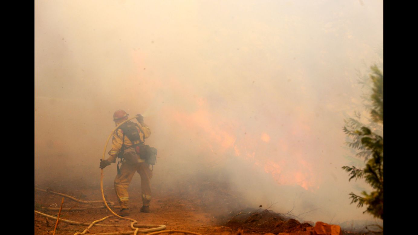 A firefighter is shrouded in smoke near Fresh Pond on September 17.