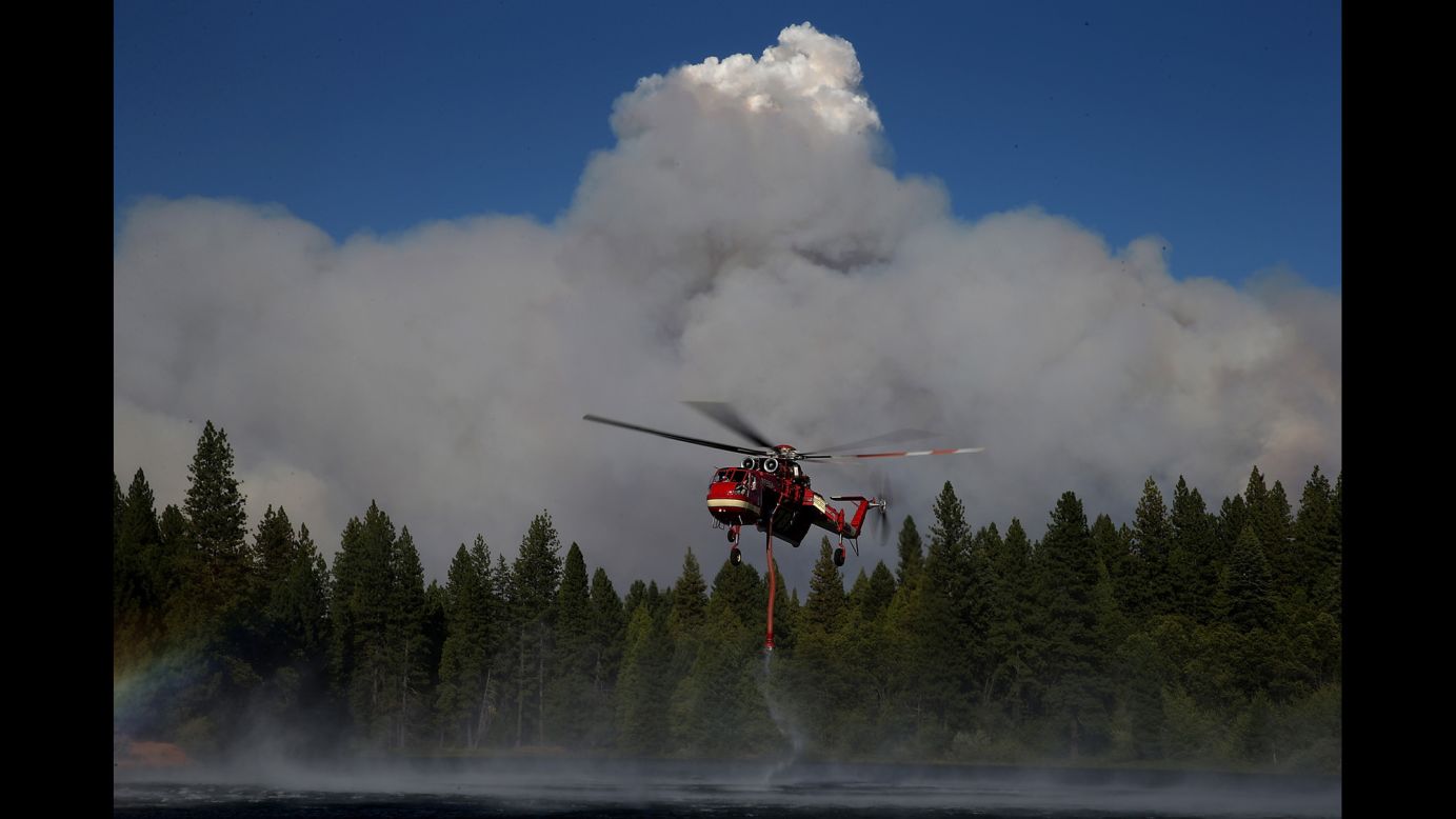 A firefighting helicopter collects water from a reservoir in Pollock Pines on September 17.