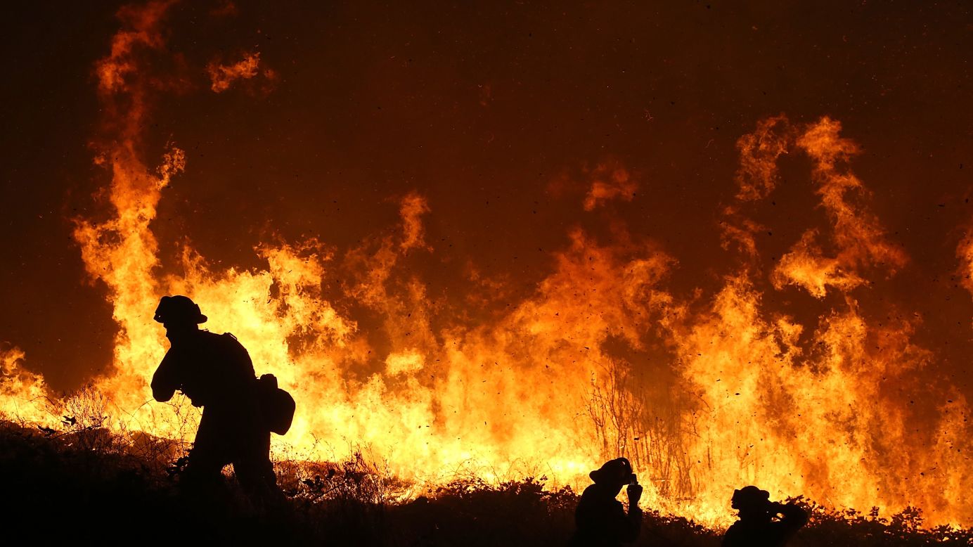 Firefighters monitor a backfire as they battle the King Fire in Fresh Pond on September 17.