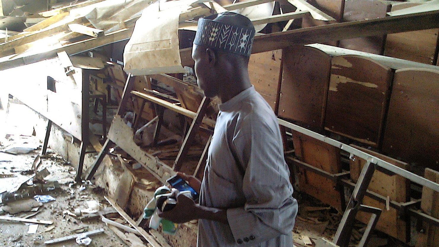 A student looks over at the damage to a lecture hall at the Federal College of Education in the northern Nigerian city of Kano, on September 17, 2014.