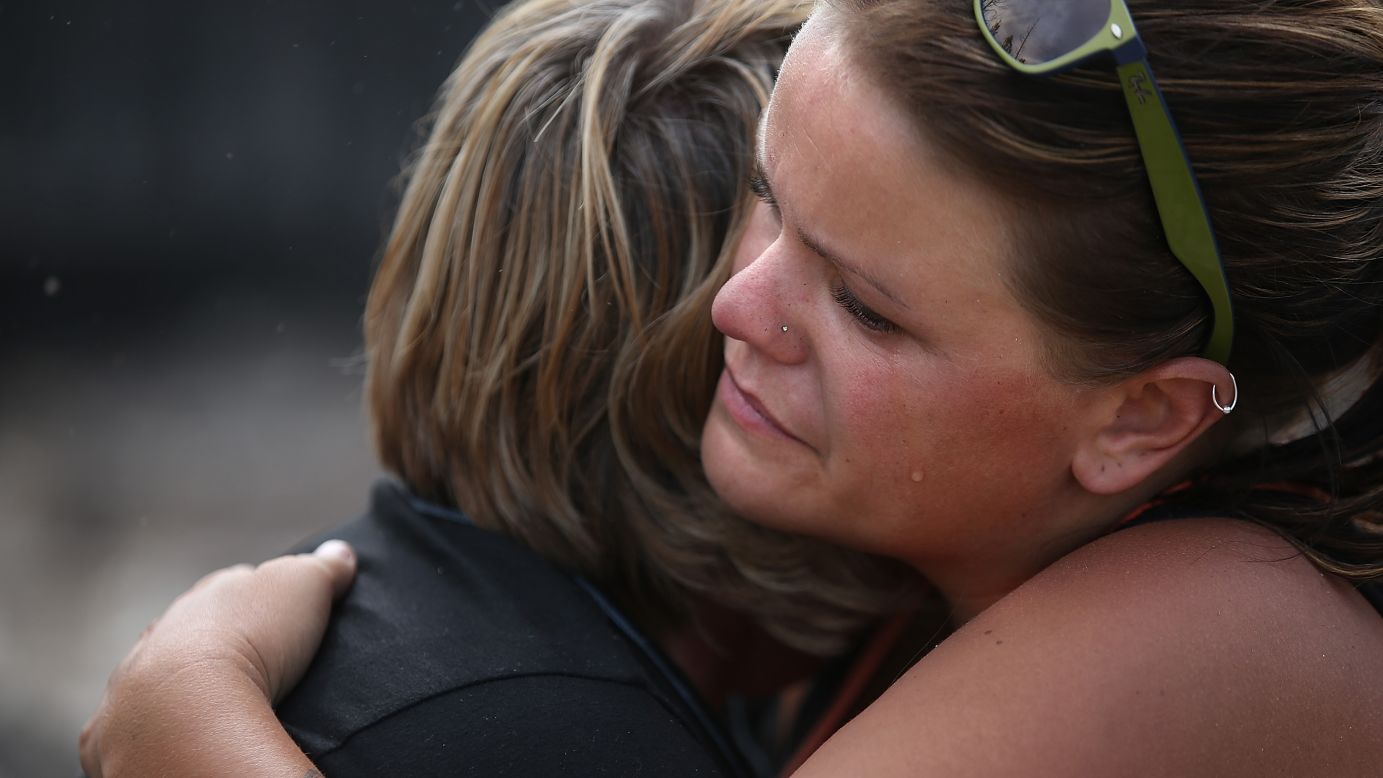 Shelley Besk, right, embraces her mother, Kathy, as they stand in the ruins of their Weed home on September 16.