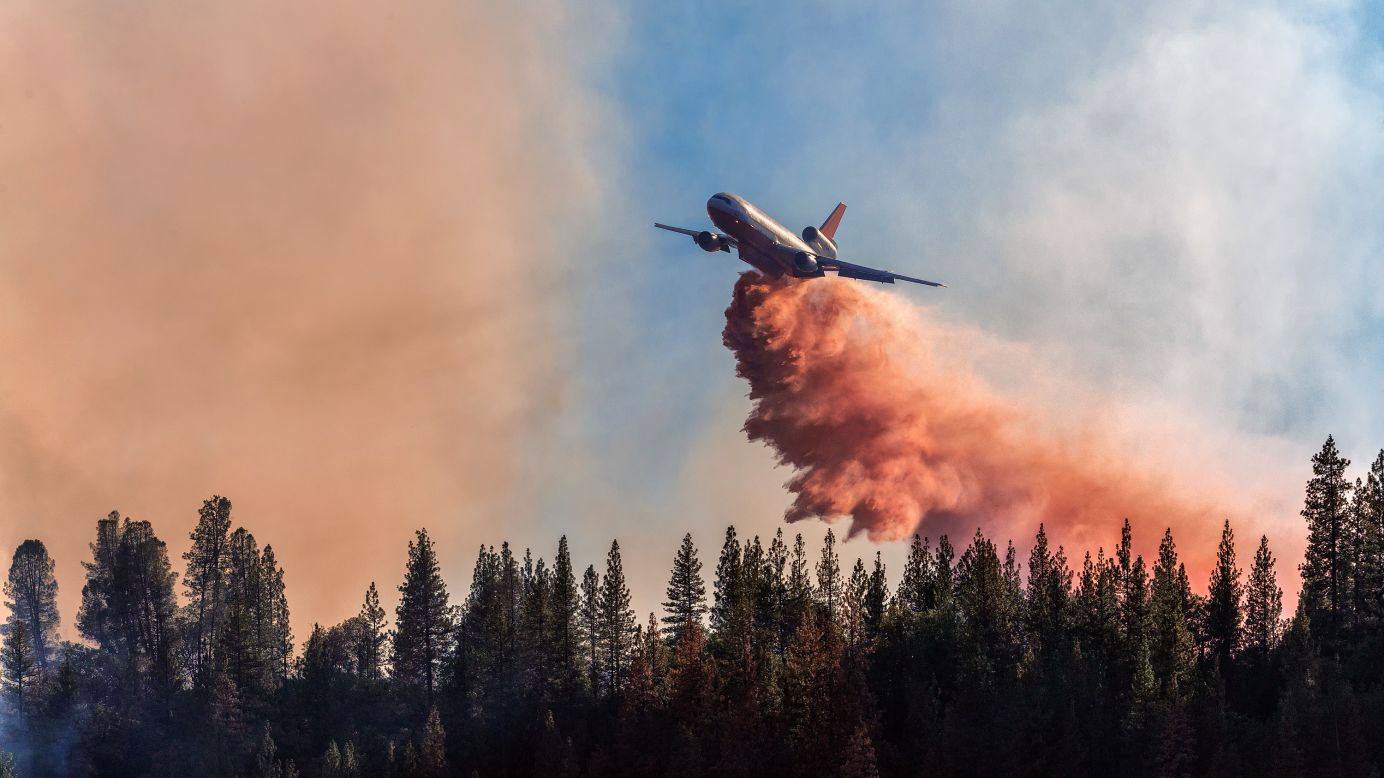 An airplane drops fire retardant over a fire at Bass Lake on September 14.