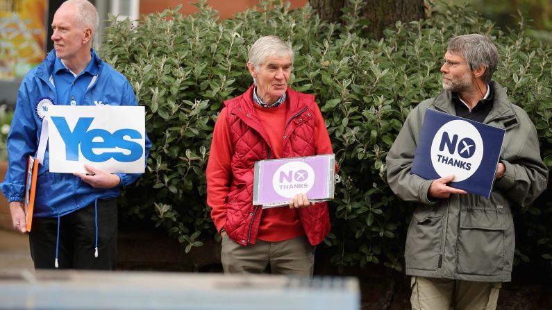 Campaigners on both sides of Scotland's independence referendum stand outside a polling station in Edinburgh on September 18.