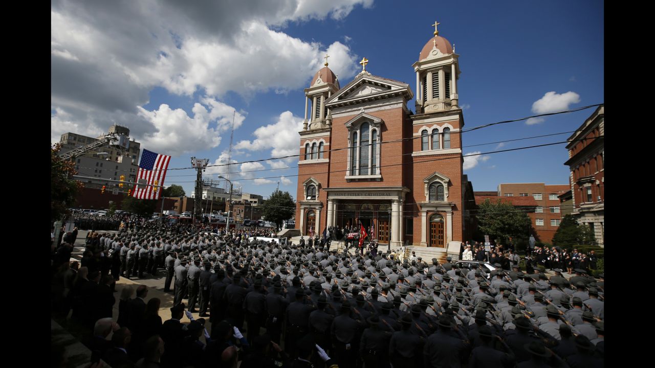 An honor guard carries the casket of Cpl. Bryon K. Dickson, a Pennsylvania state trooper, from his funeral service Thursday, September 18, in Scranton, Pennsylvania. Dickson was one of <a href="http://www.cnn.com/2014/09/14/justice/pennsylvania-shooting/index.html">two state troopers shot last week</a> while they were leaving their police barracks in Blooming Grove, Pennsylvania. The other trooper, Alex T. Douglass, was severely wounded.