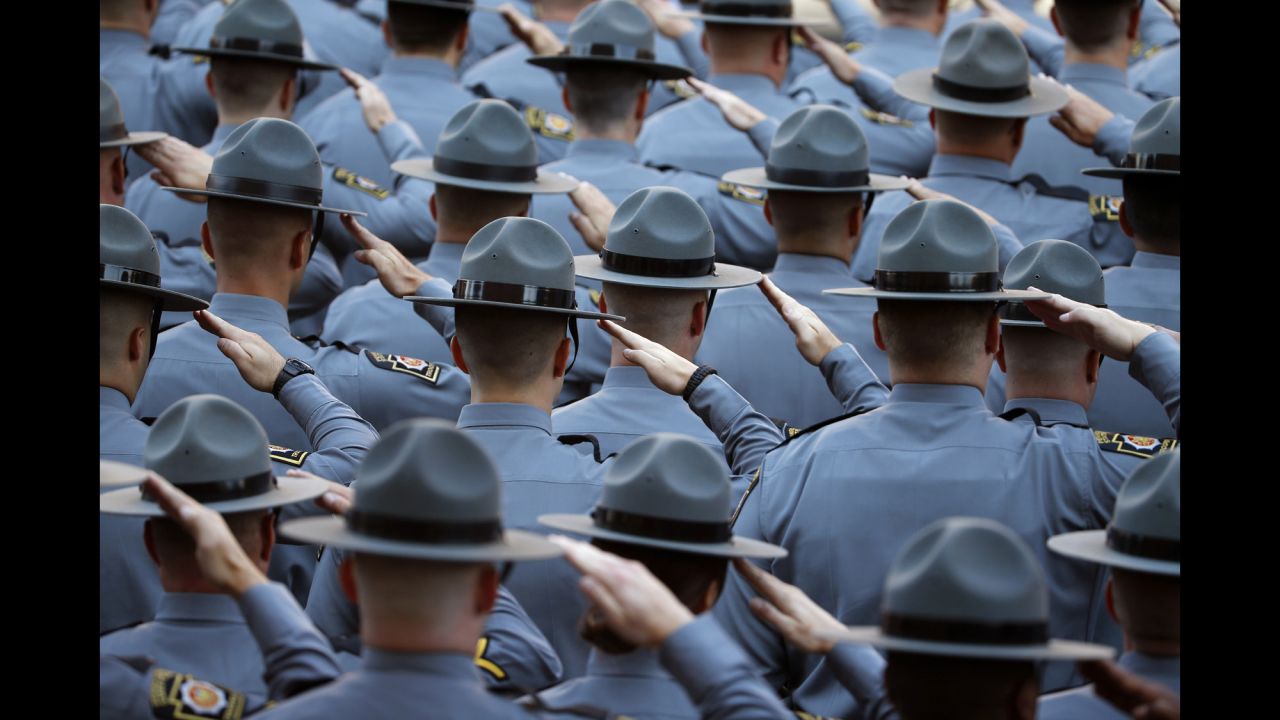 Law enforcement officers salute as the honor guard arrives for Dickson's funeral service on September 18.