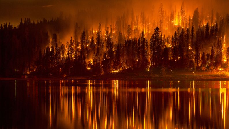 A wildfire approaches the shore of California's Bass Lake on Sunday, September 14. California Gov. Jerry Brown declared a state of emergency in two counties where <a href="http://www.cnn.com/2014/09/18/us/gallery/california-oregon-wildfires/index.html">wildfires</a> have torched tens of thousands of acres, destroying some homes and threatening others.