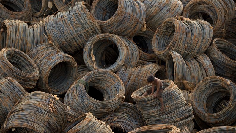 A child looks for metal scraps among cables that were sitting on a barge Tuesday, September 16, in Manila, Philippines.