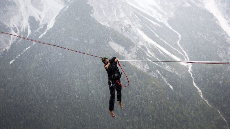 An extreme athlete hangs between rocks Friday, September 12, during the International Highline Meeting, which brought together many highline enthusiasts in the northern Italian Alps.