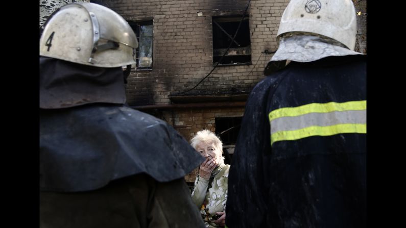 A woman speaks with firefighters in front of an apartment building that was damaged after shelling in Donetsk, Ukraine, on Wednesday, September 17. <a href="http://www.cnn.com/2014/08/07/europe/gallery/ukraine-crisis/index.html">Fighting between Ukrainian troops and pro-Russian rebels in the country</a> has left more than 3,000 people dead since mid-April, according to the United Nations.