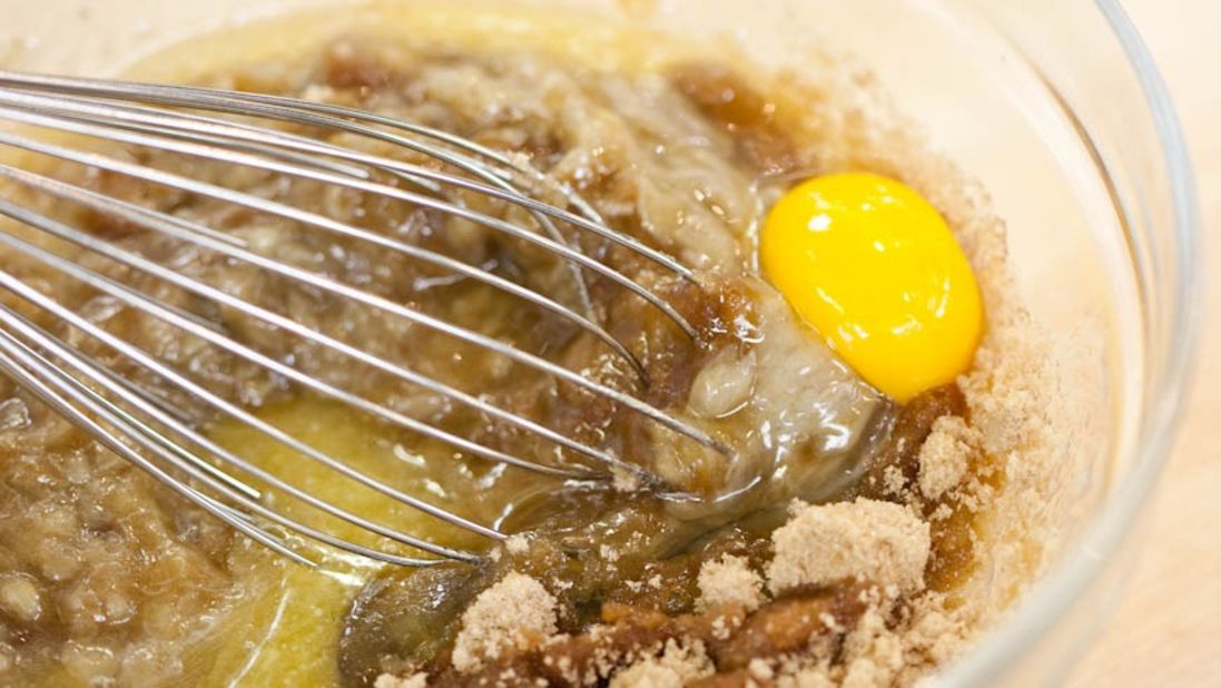 7. Whisk in melted butter, 2 large eggs, 3/4 cup packed (5 1/4 ounces) light brown sugar, and 1 teaspoon vanilla extract.