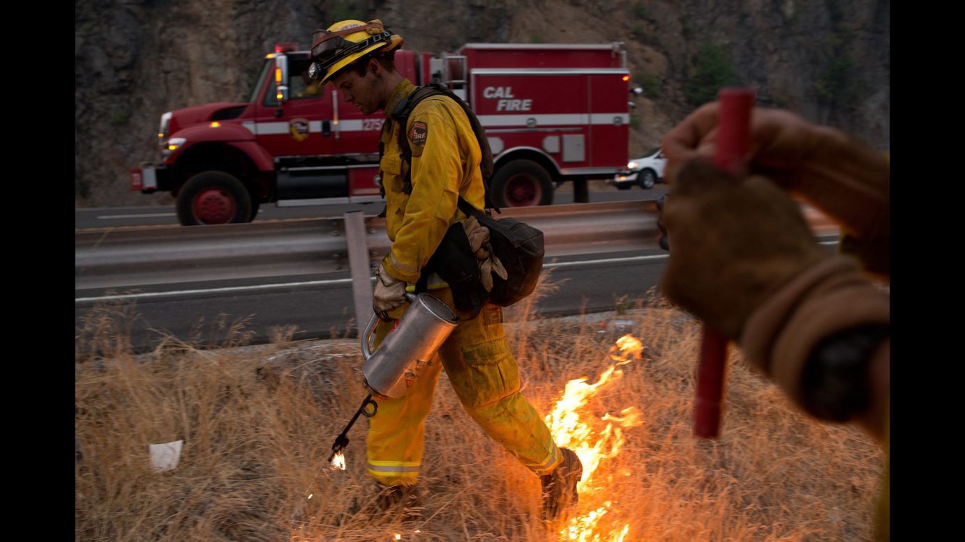 Firefighters use a drip torch to burn away excess dry brush during controlled fire operations near Pollock Pines, California, on September 18.