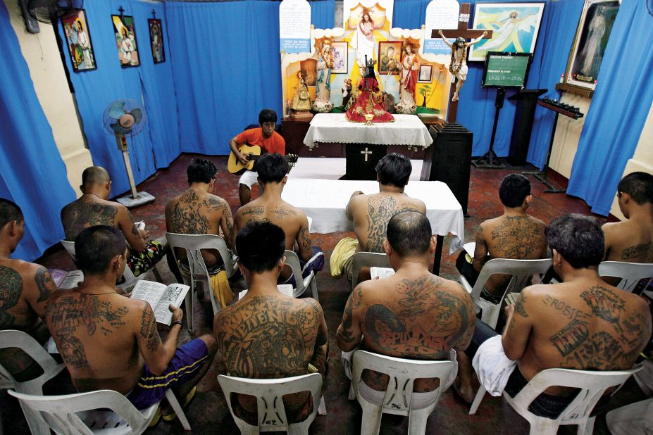 Inmates of the Makati City jail in Manila attend Catholic worship in 2010. Their tattoos identify them as members of particular gangs.