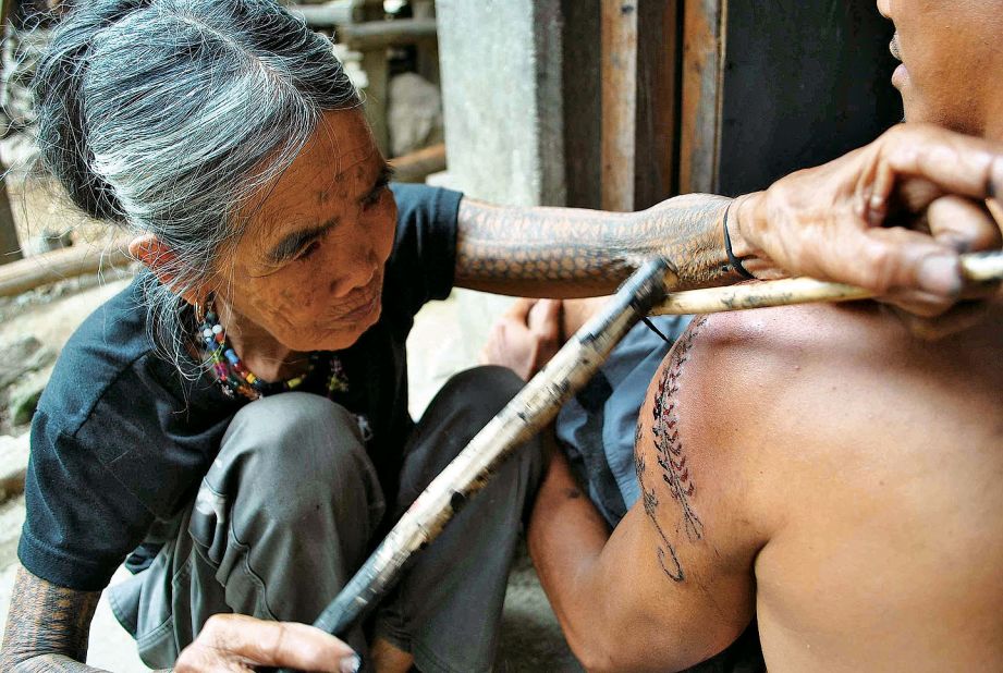 Whang-ud, 92, uses a lemon thorn attached to a wand to make these traditional tattoos.