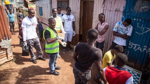 A health worker talks with residents on how to prevent the Ebola virus in Freetown, Sierra Leone on September 20, 2014.