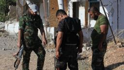 Syrian pro-government forces inspect the ground near a damaged building on the outskirts of the city of Hama on September 20, 2014. Syrian troops have regained control of villages near a military air base in the central province of Hama earlier this month, pushing back rebel fighters in the area.