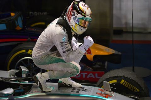 Lewis Hamilton poses on top of his car after winning the 2014 Singapore Grand Prix.