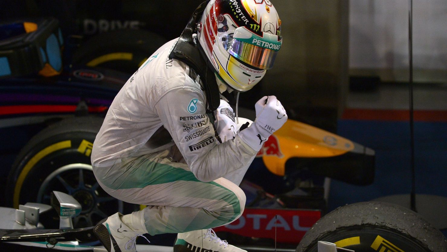 Lewis Hamilton poses on top of his car after winning the Singapore GP to take the title lead.