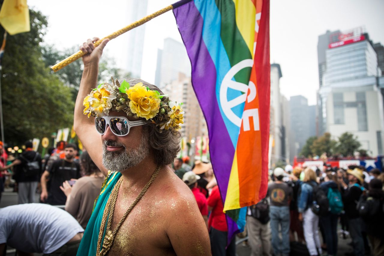 A man waves a rainbow flag as he marches in New York.