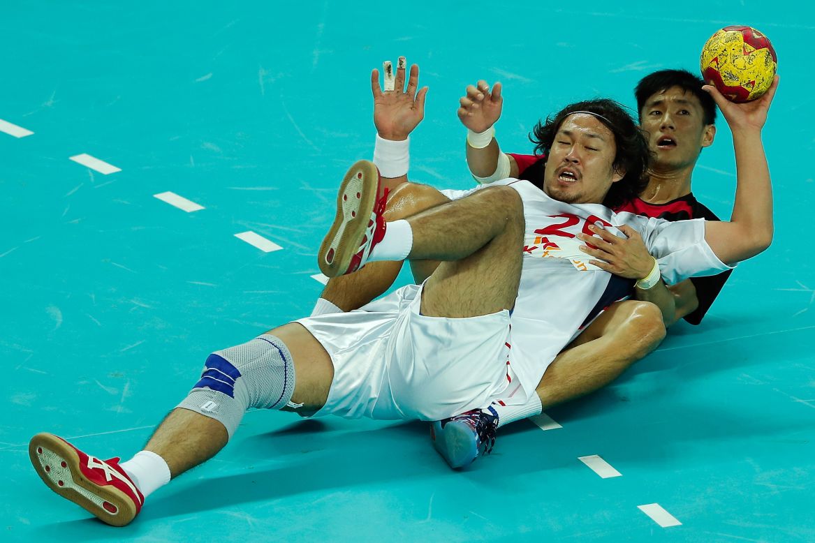 Daichi Komuro of Japan and Chia-Wei Weng of Chinese Taipei grapple for the ball during the Handball Men's Group D match on day two of the Games, September 21.