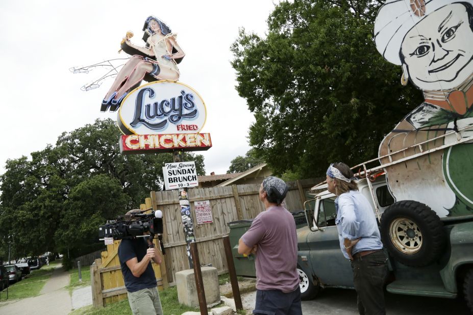 Evan Voyles shows Rowe the sign he made for "Lucy's Fried Chicken." Volyes runs "The Neon Jungle," a sign making business in Austin, Texas. 