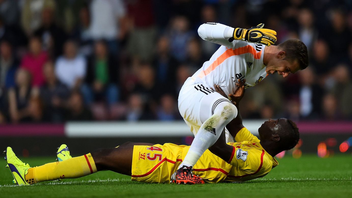 West Ham goalkeeper Adrian, top, and Liverpool forward Mario Balotelli clash after a Balotelli tackle Saturday, September 20, in London. West Ham won the Premier League match 3-1.