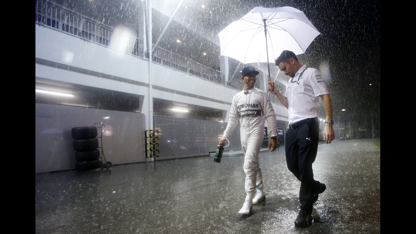 After winning the pole for the Singapore Grand Prix, Formula One driver Lewis Hamilton smiles as he walks with his assistant on Saturday, September 20. Hamilton would go on to win the race the next day and move to the top of the drivers' standings.