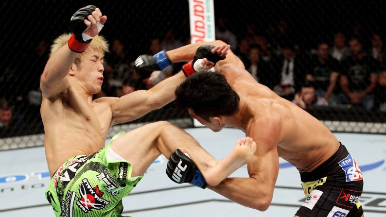 Kyung Ho Kang, right, goes for a takedown on Michinori Tanaka during their bantamweight bout Saturday, September 20, at UFC Fight Night in Saitama, Japan. Kang won by split decision.