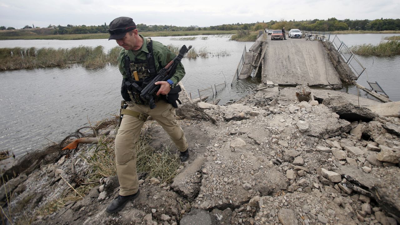 A pro-Russian rebel guards a destroyed bridge in Nyzhnya Krynka, Ukraine, on Tuesday, September 23. 