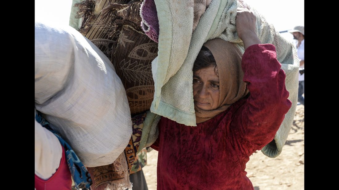 A woman carries belongings across the border between Turkey and Syria on September 23.