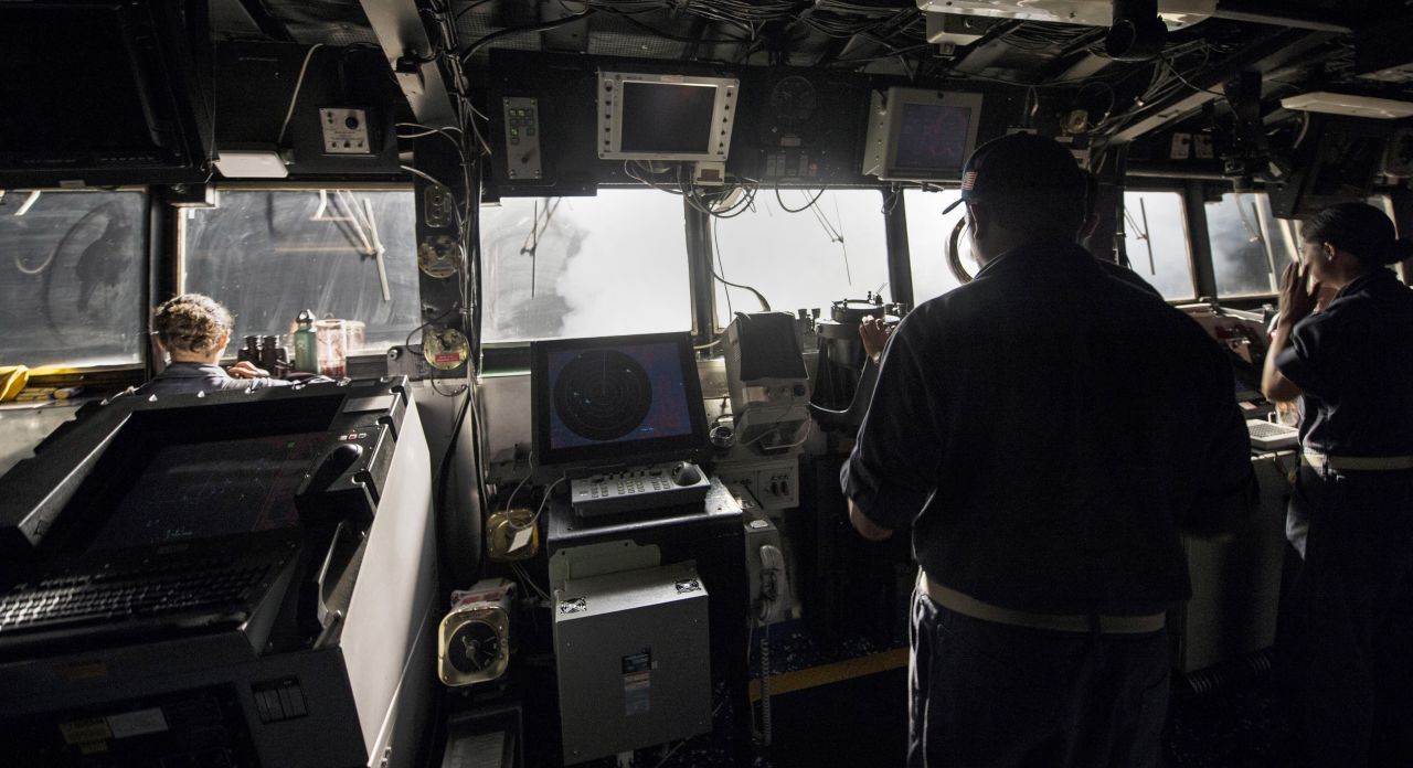 U.S. sailors stand on the bridge of the USS Philippine Sea while Tomahawk cruise missiles are launched toward targets in Syria on September 23.