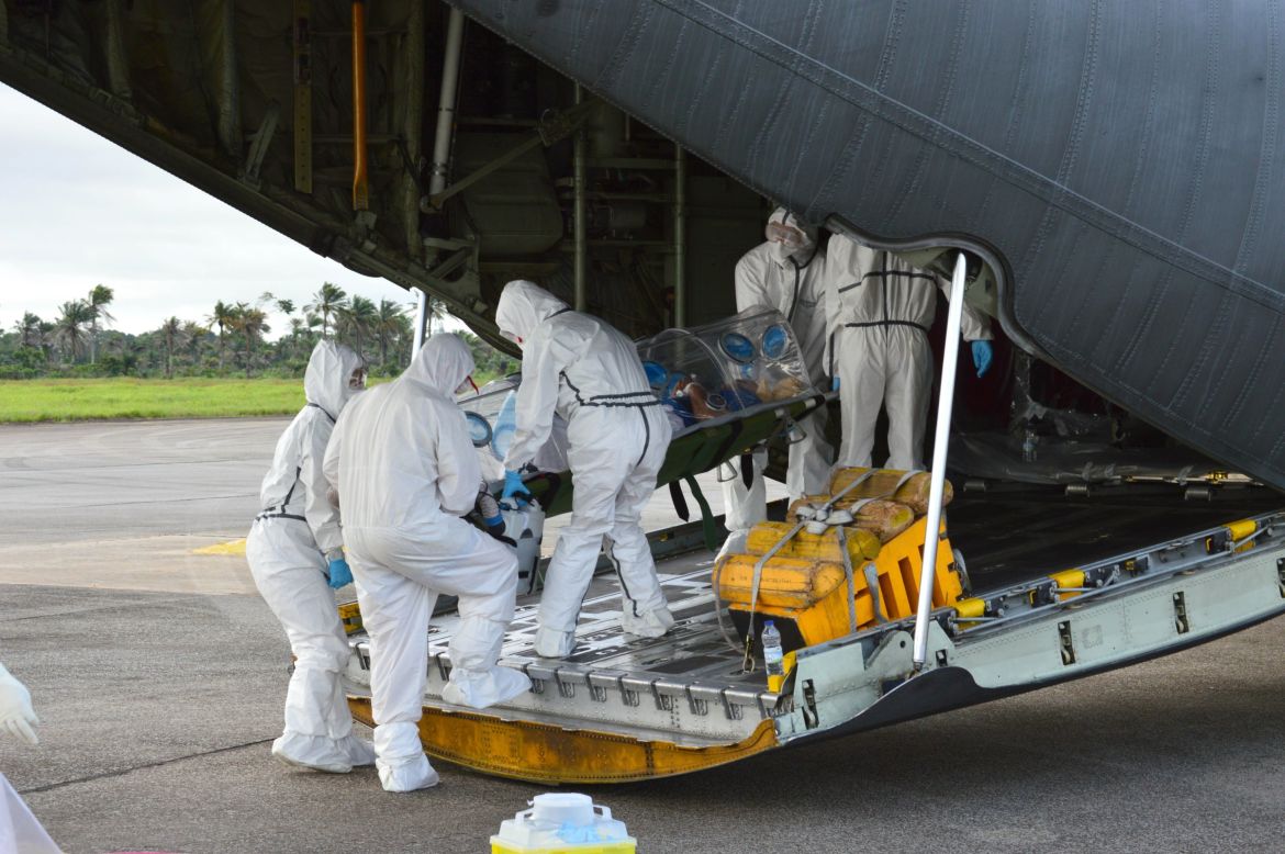 Medics load an Ebola patient onto a plane at Sierra Leone's Freetown-Lungi International Airport on September 22, 2014.