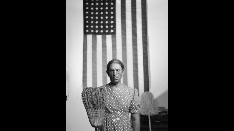 Malkovich mimics the "American Gothic, Washington D.C."  photo that was taken by Gordon Parks in 1942.