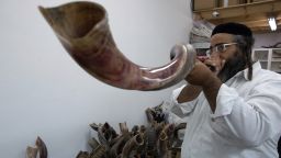 An Ultra-Orthodox Jewish man tests a Shofar (a religious musical instrument made from a ram's horn) before buying it at a factory in Tel Aviv on September 22, 2014 ahead of the Jewish New Year. 