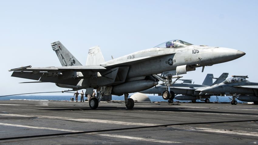 FILE- In this file image provided by the U.S. Navy on Tuesday, Sept. 23, 2014, a F/A-18E Super Hornet attached to the Tomcatters of Strike Fighter Squadron (VFA) 31 lands aboard the aircraft carrier USS George H.W. Bush after conducting strike missions against Islamic State group and other targets in Syria. Arab countries' prominent role in initial airstrikes against the Islamic State group in Syria shatters the notion of what a typical American-led military operation looks like and won the Mideast allies praise from U.S. President Barack Obama for their willingness to stand "shoulder-to-shoulder" with the United States. (AP Photo/U.S. Navy, Mass Communication Spc. 3rd Class Brian Stephens-file)