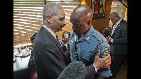 Holder talks with Capt. Ron Johnson of the Missouri State Highway Patrol in Ferguson, Missouri, in August 2014. Holder traveled to Ferguson to oversee the federal government's investigation into a police officer's shooting of 18-year-old Michael Brown.