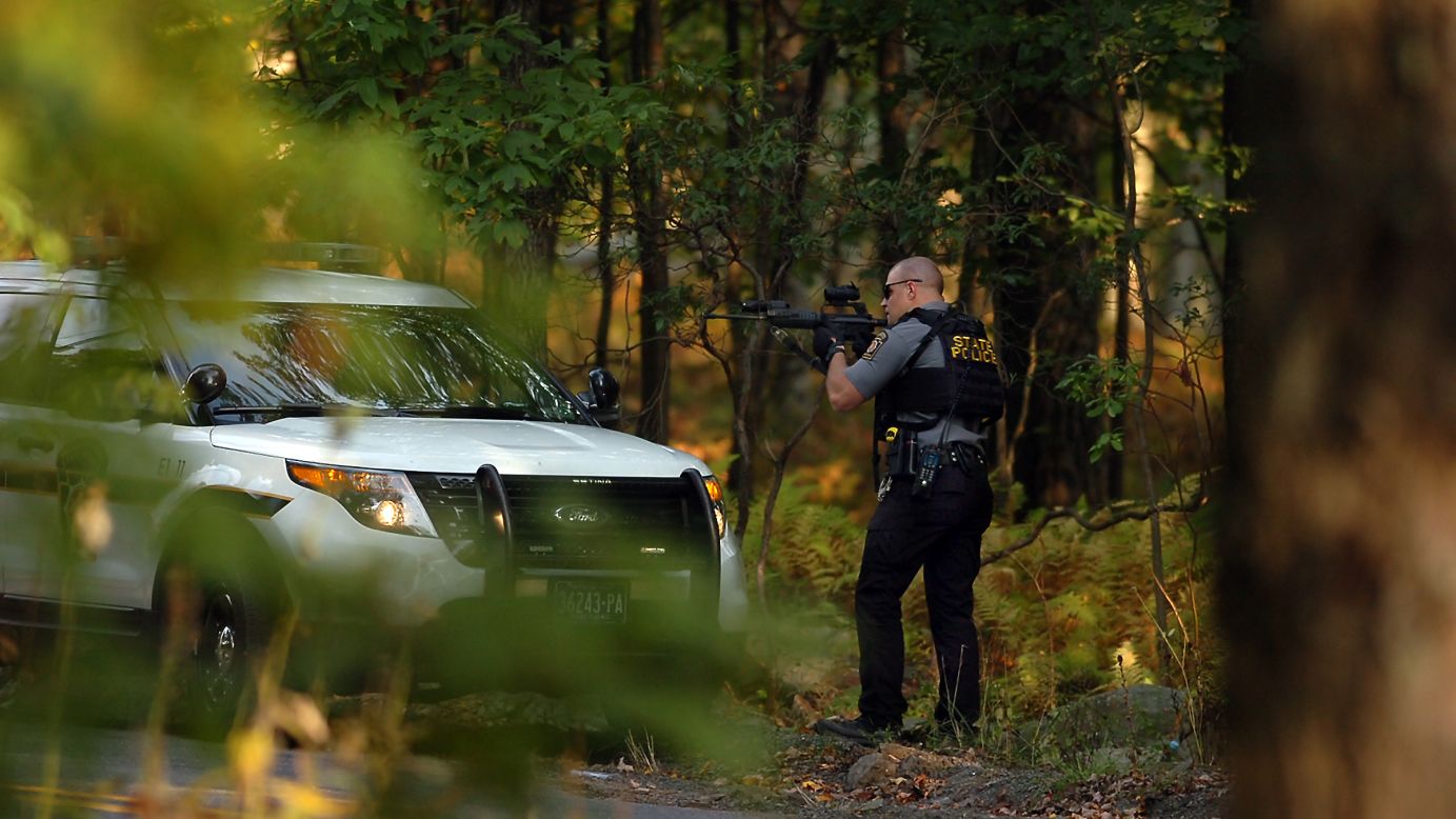 A Pennsylvania state trooper draws his weapon in Price Township, Pennsylvania, during a manhunt for Eric Matthew Frein on Sunday, September 21. Frein <a href="http://www.cnn.com/2014/09/22/justice/pennsylvania-suspected-cop-killer/index.html">is wanted</a> for the shootings of two state police officers, one of whom died.