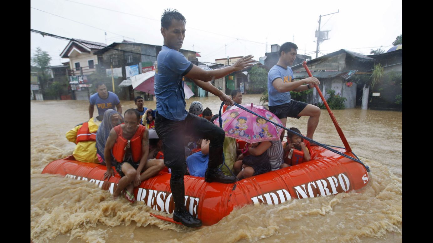 Flood victims ride in a rescue boat after their homes were swamped in Manila, Philippines, on Friday, September 19. Heavy rain in the capital city caused flooding in many areas and led to the closing of schools, government offices and financial markets.