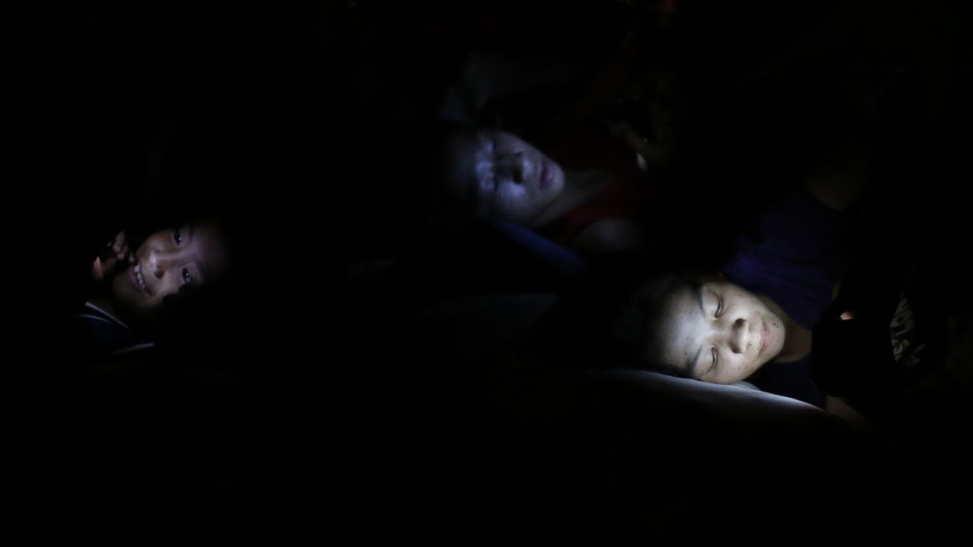 Flood victims in Manila, Philippines, use electronic devices as they rest at an evacuation center on Friday, September 19.