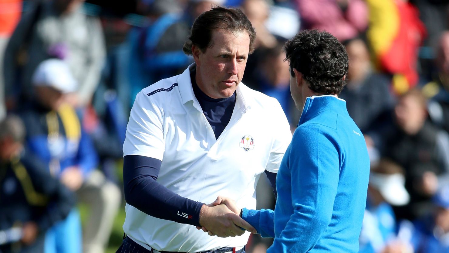 Phil Mickelson shakes Rory McIlroy's hand after claiming a vital point for Team USA in the final fourball match on Friday.