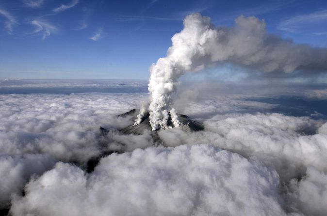 An aerial view shows the dense white plume of Mount Ontake rising high into the sky. 