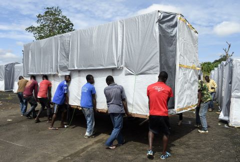 Workers move a building into place as part of a new Ebola treatment center in Monrovia on September 28, 2014.