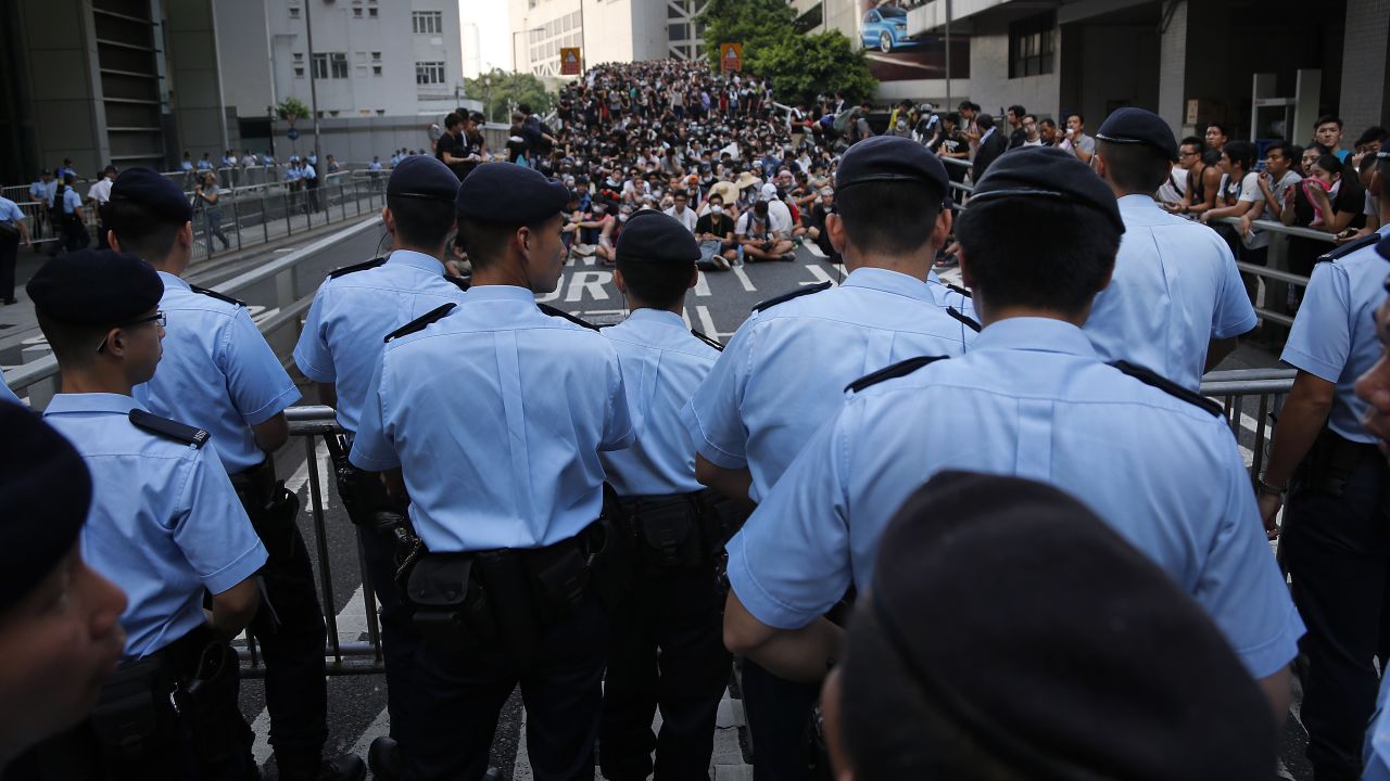 Pro-democracy protesters sit in a road as they face off with local police on September 29.