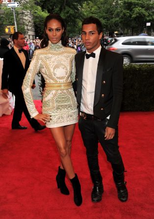 Rousteing is also known for casting diverse models for his catwalk shows and advertising campaigns, and he is pictured here with supermodel Joan Smalls, a regular fixture on the Balmain runway.