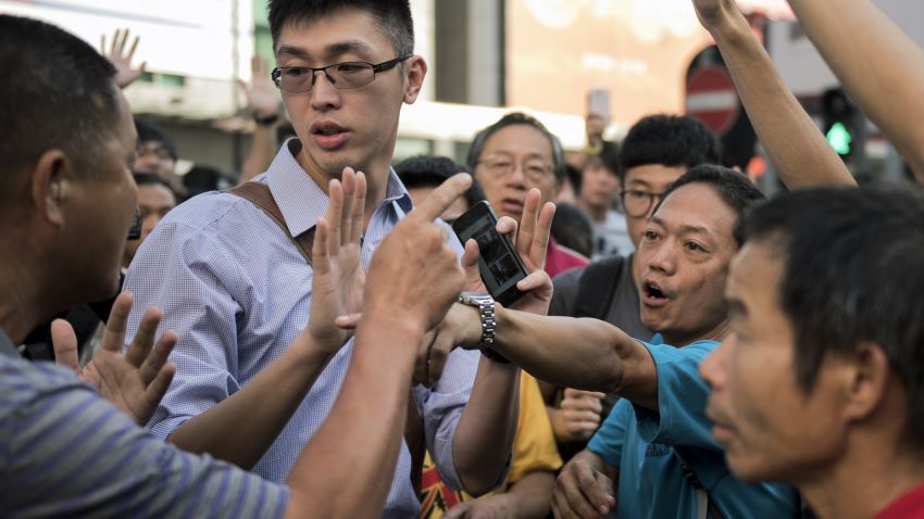 Pro-democracy protesters argue with a man (L) opposing their occupation of Nathan Road, a major route through the heart of the Kowloon district of Hong Kong, on September 29, 2014. Police fired tear gas as tens of thousands of pro-democracy demonstrators brought parts of central Hong Kong to a standstill on September 28, in a dramatic escalation of protests that have gripped the semi-autonomous Chinese city for days. AFP PHOTO / ALEX OGLE (Photo credit should read Alex Ogle/AFP/Getty Images)